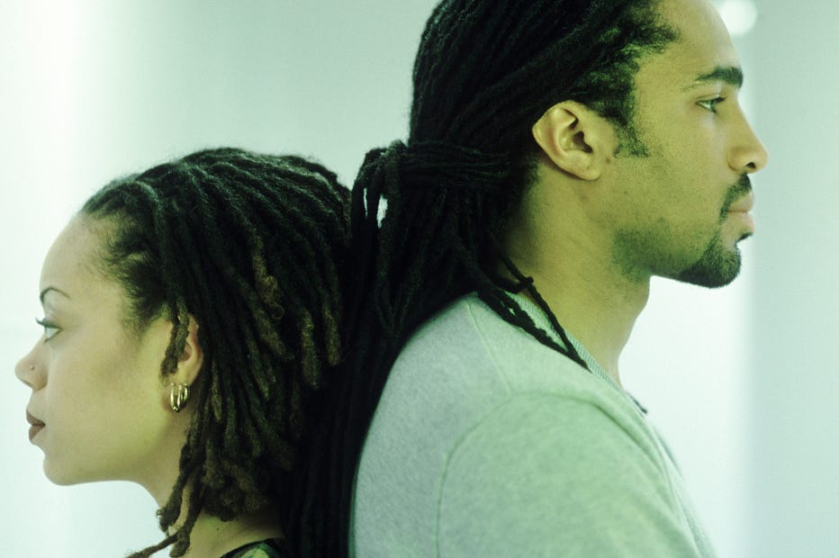A photo of an African-American couple standing back-to-back, discontent.